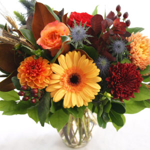 fall flowers in a vase with berries and fall foliage