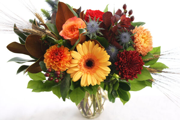 fall flowers in a vase with berries and fall foliage