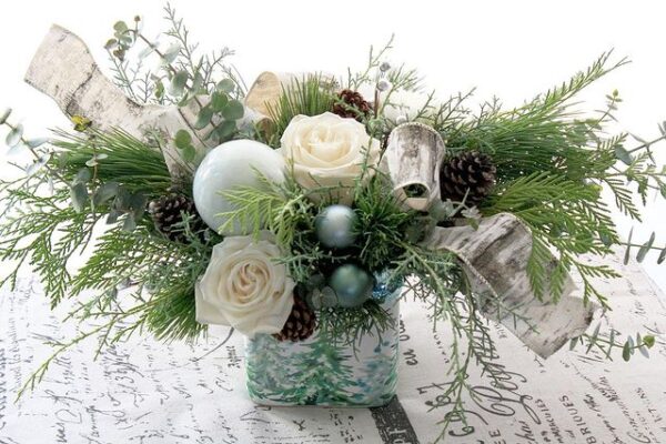 Christmas greenery, pine boughs, cedar, carolina saphire, white roses, white flowers, birch ribbon, in winter ceramic vase
